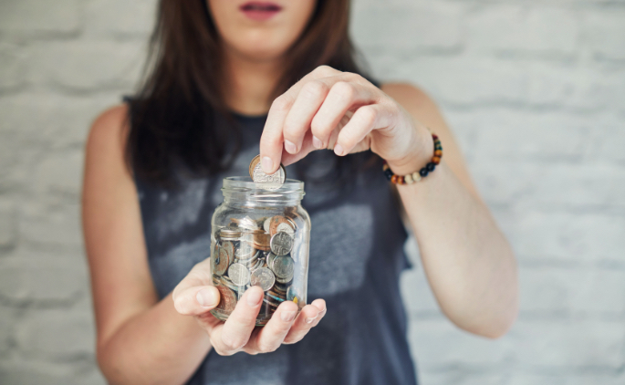 A woman putting change in a jar